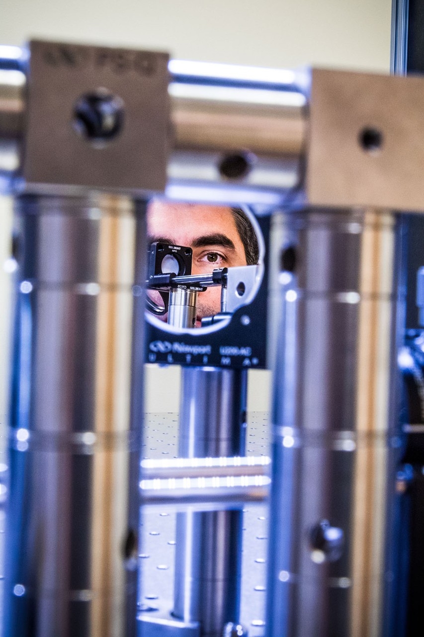 Man's face looking into the mirror of an adaptive optics microscope