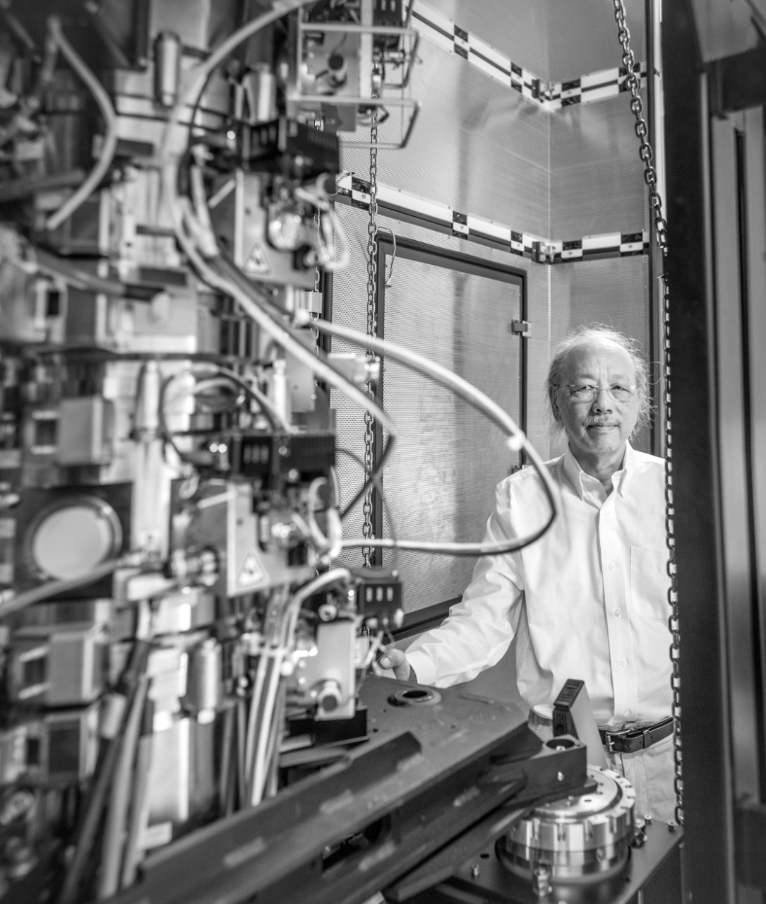 Wah Chiu stands alongside an electron microscope at the Stanford-SLAC Cryo-EM Center.