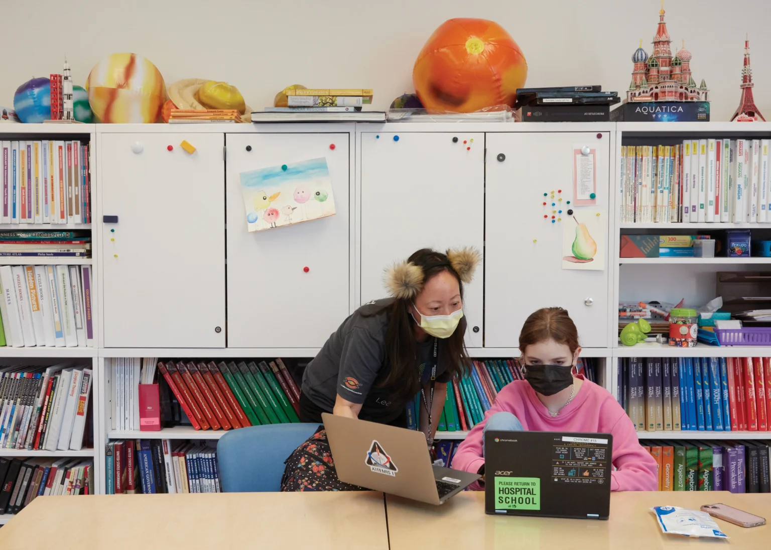 Photo of Stanford Hospital School teacher Kathy Ho assisting 15-year-old patient Ella Walsh with an assignment at Lucile Packard Children’s Hospital Stanford.