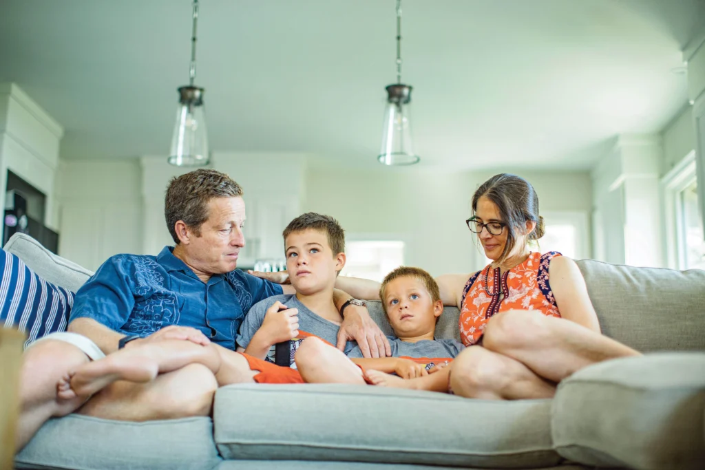 Photo of the parents and brother of 11-year-old Tony Graglia sitting on a couch in their home.