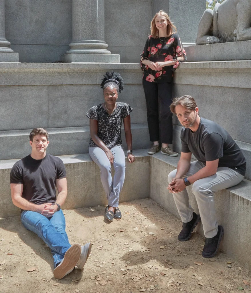 Image of four PhD students sitting together on the Stanford University campus.